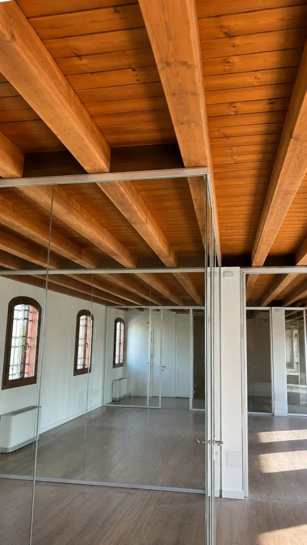 Parete vetrata sotto un soffitto con travi in legno