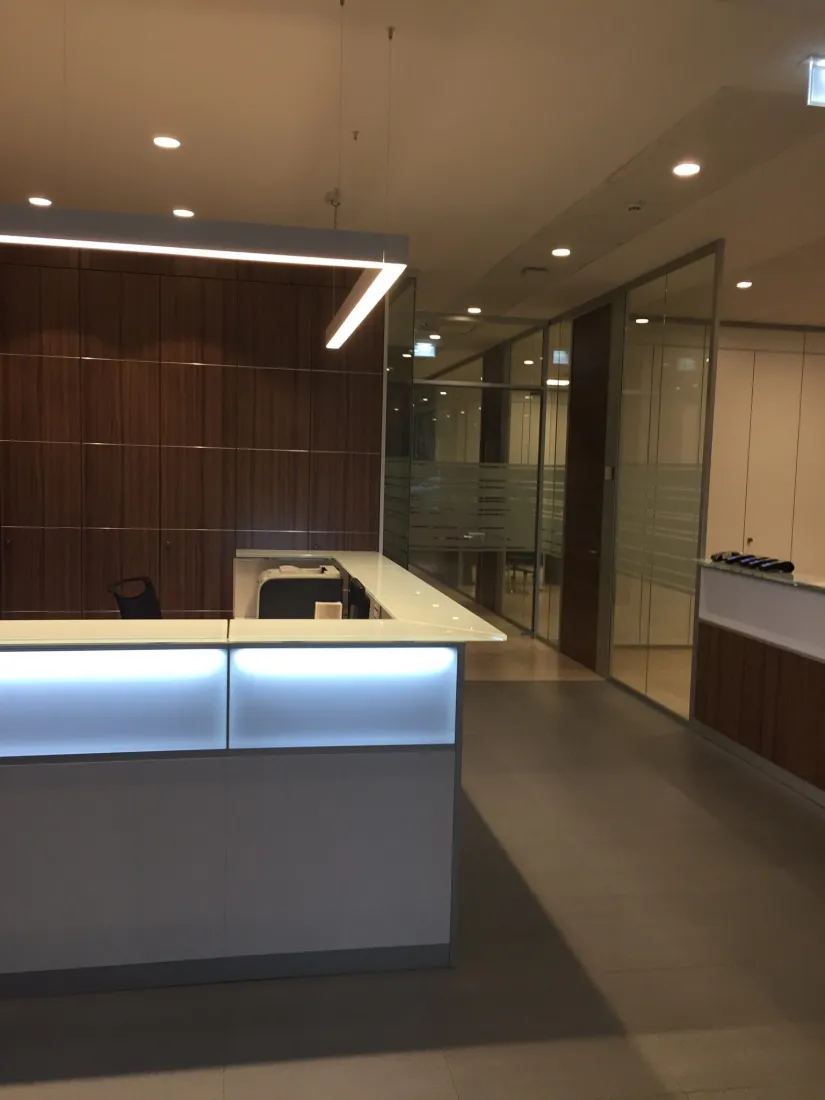 Reception con pareti attrezzate in legno e pareti vetrate