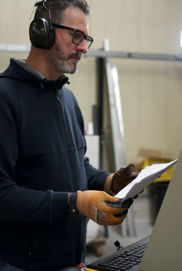 Operatore che legge un disegno tecnico in officina