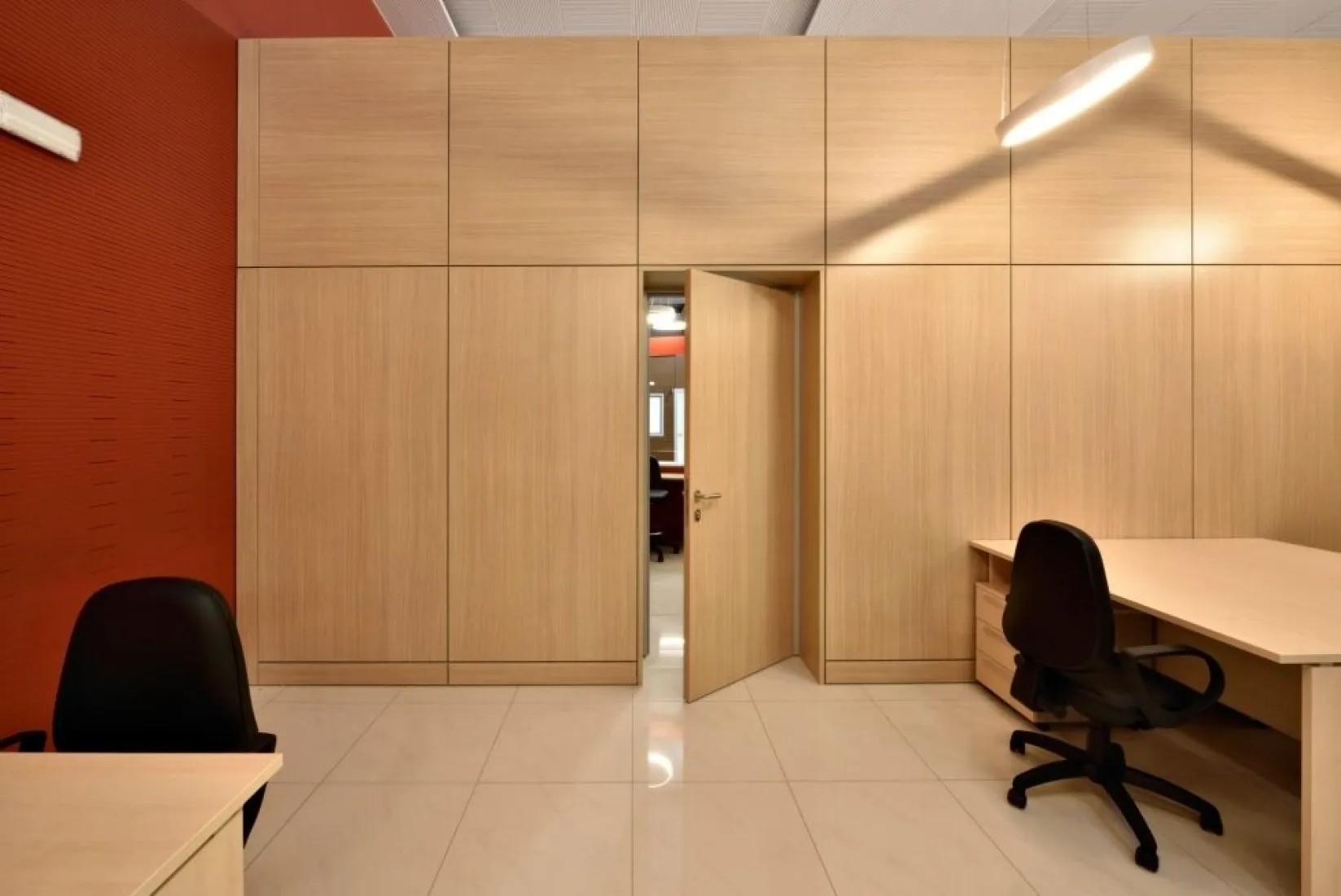 Ufficio con pareti attrezzate in legno e parete rossa