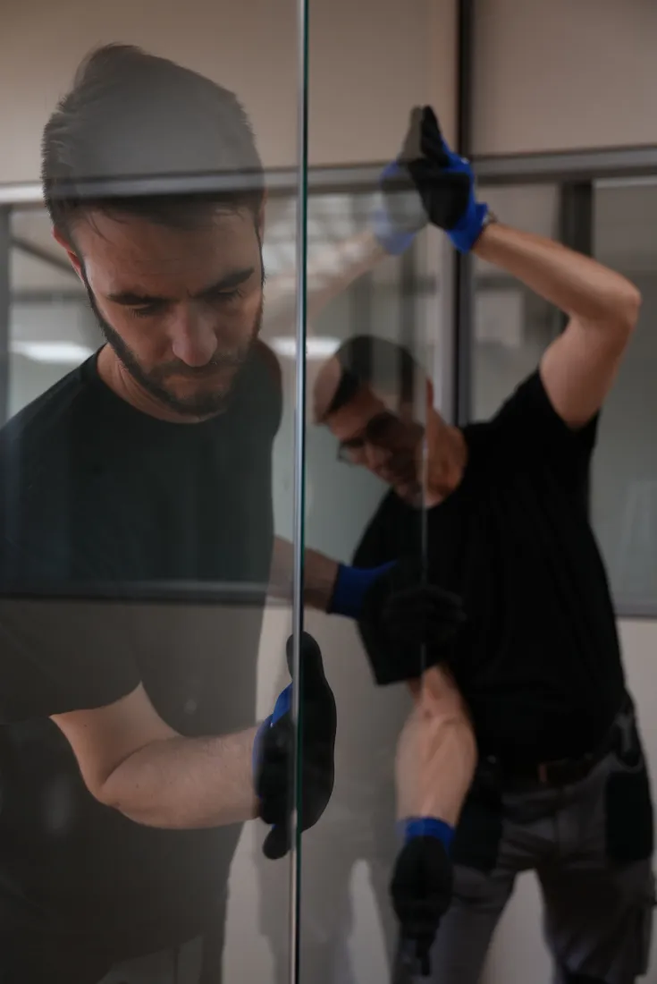Operatore che monta una parete in vetro