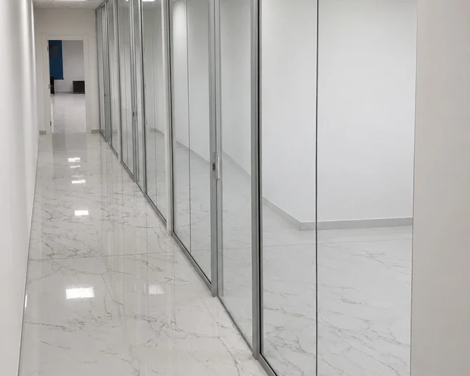 Corridoio in marmo bianco con pareti vetrate