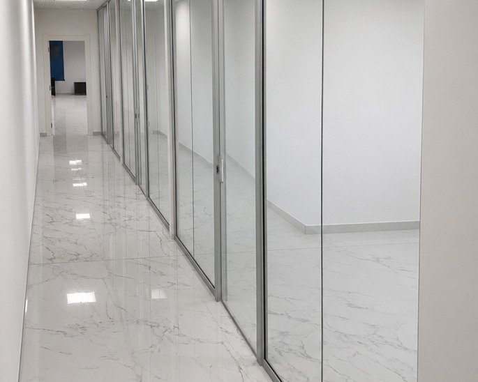Corridoio in marmo bianco con pareti vetrate